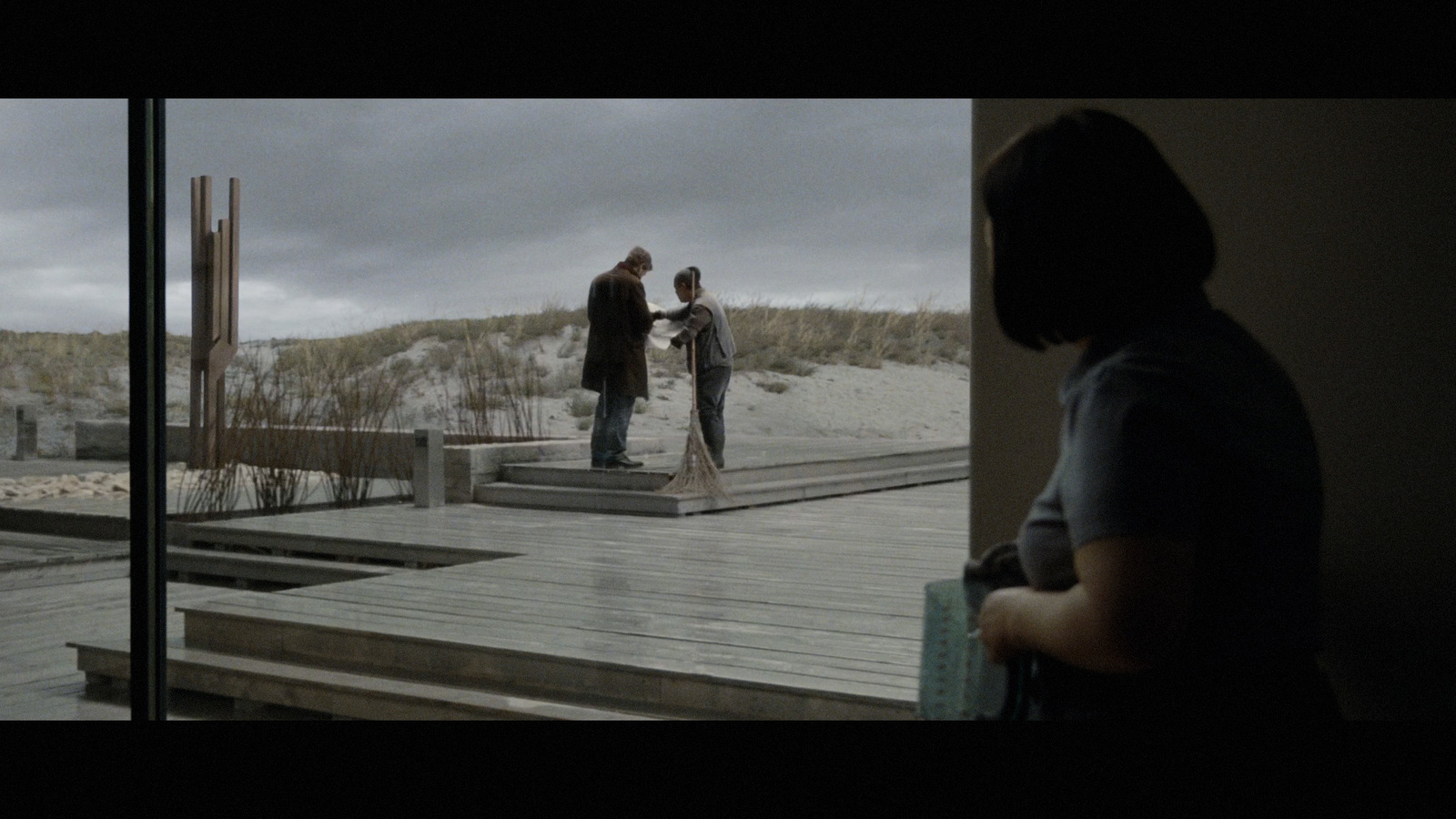 a man and woman standing on a wooden deck