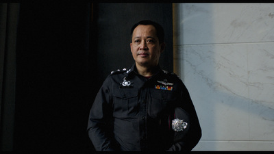 a man in a police uniform standing in front of a wall