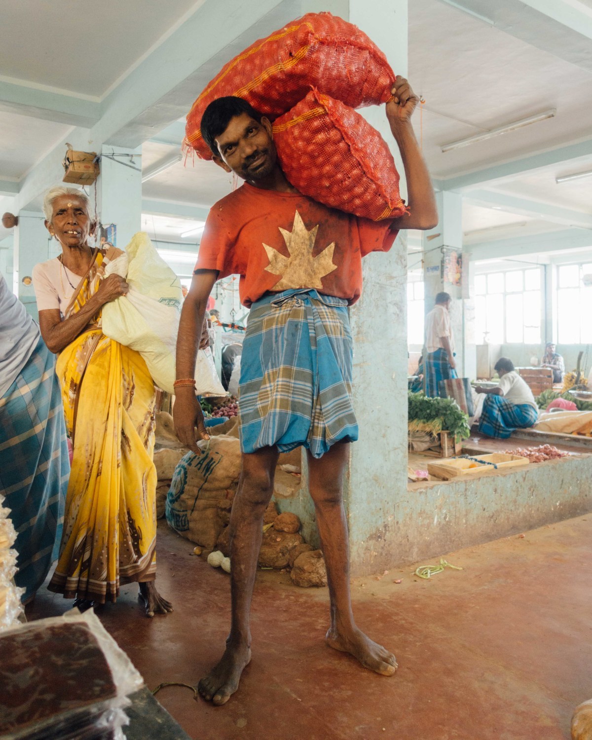 a man carrying a large bag of food on his back