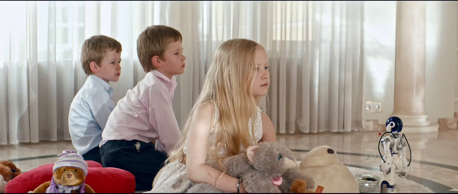 three children sitting on the floor with stuffed animals