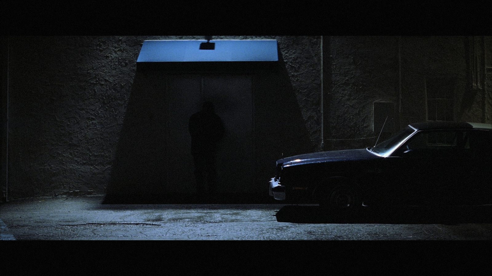 a car parked in front of a building in the dark