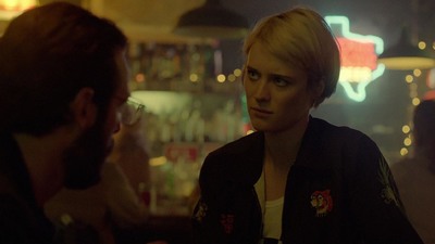 a woman standing next to a man in a bar