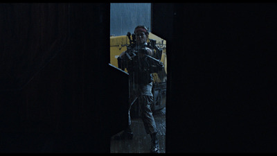 a man with a gun standing in a doorway