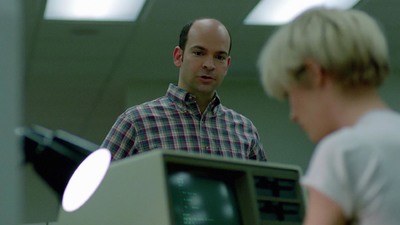 a man standing in front of a computer monitor