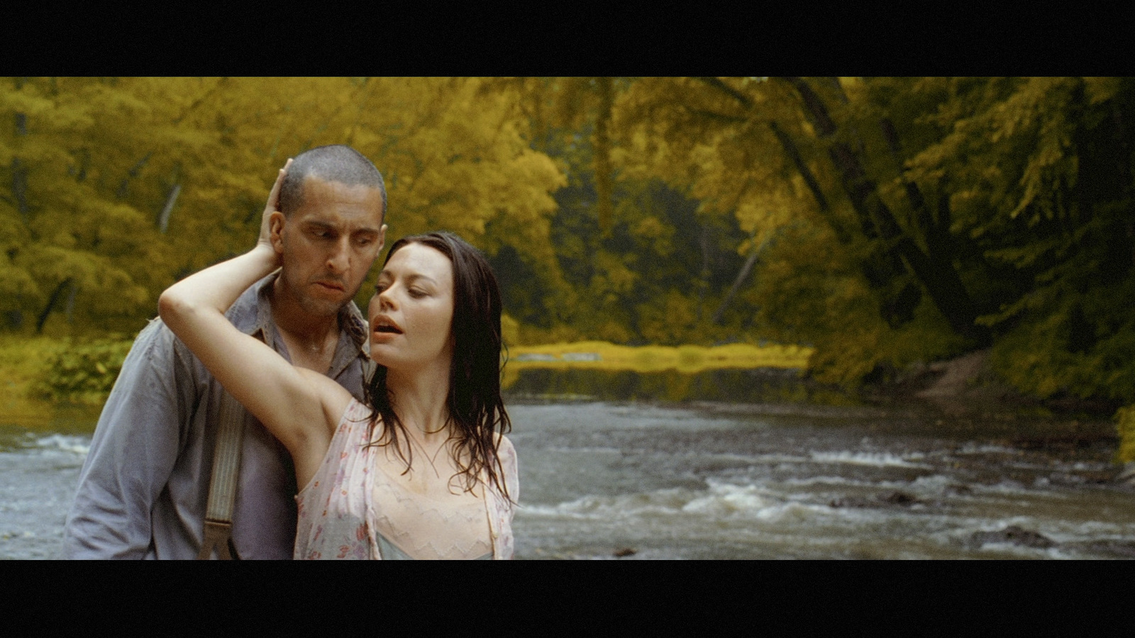 a man standing next to a woman near a river