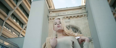 a woman standing in front of a tall building