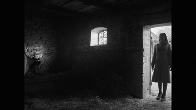 a woman standing in a doorway of a stone building