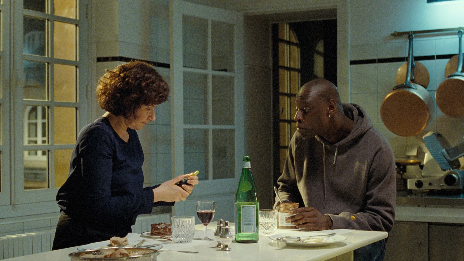 a man and a woman sitting at a table in a kitchen