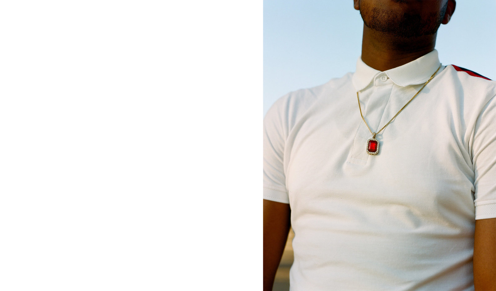 a man wearing a white shirt and a red and white necklace