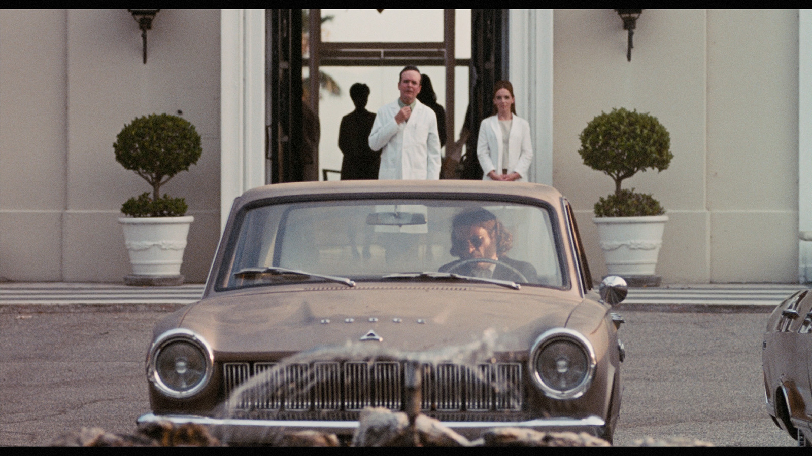 a group of people standing in front of a car