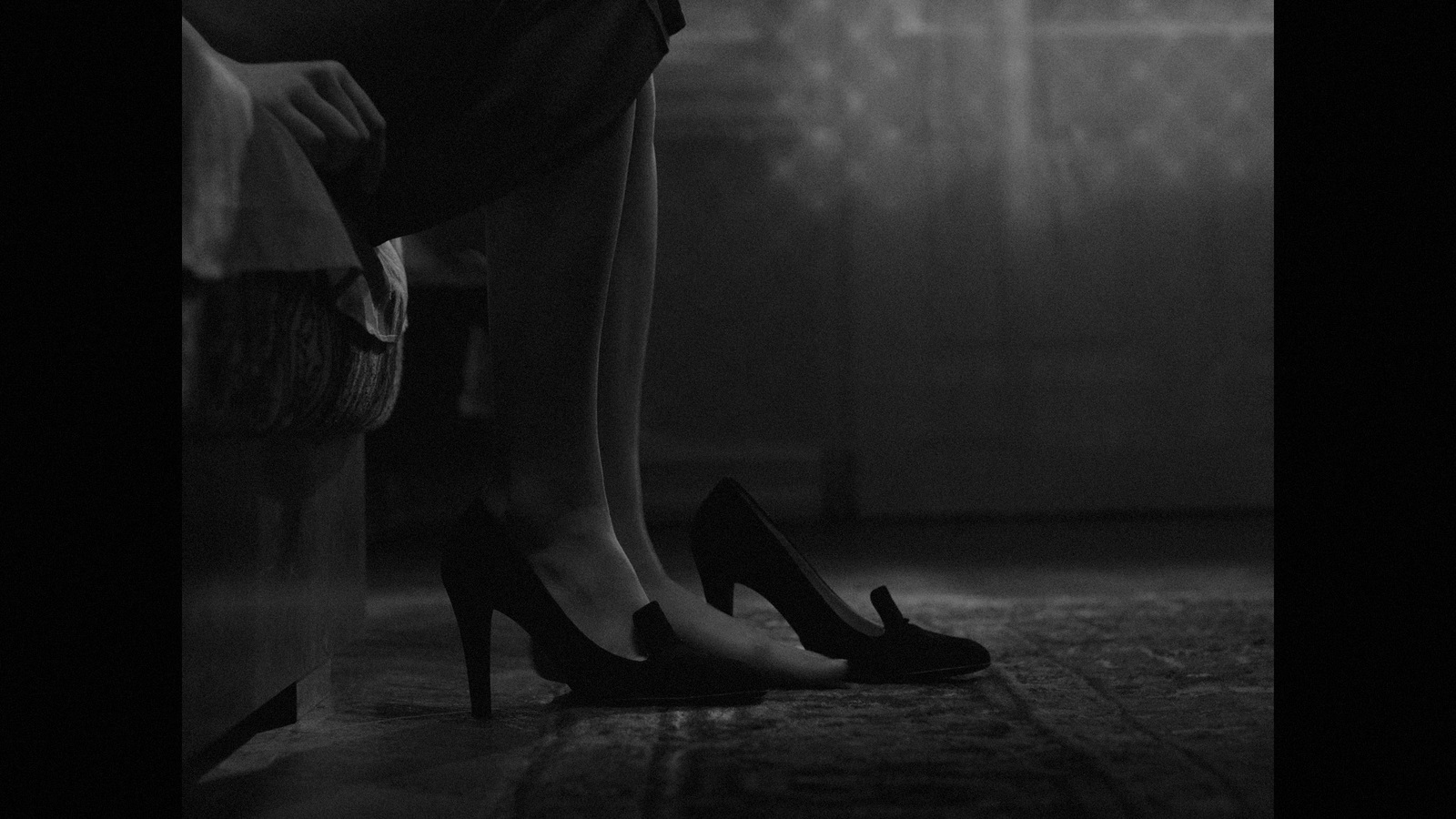 a black and white photo of a woman's legs and shoes