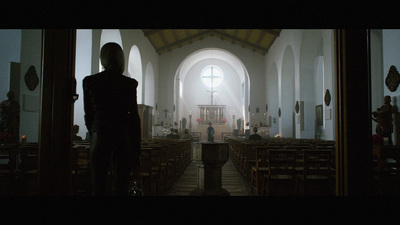 a woman standing in a church looking at the pews