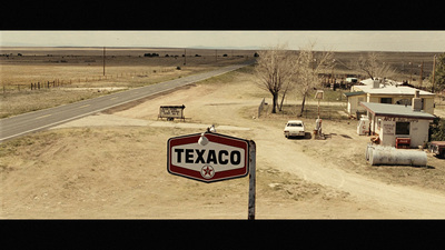 a street sign in the middle of a dirt road