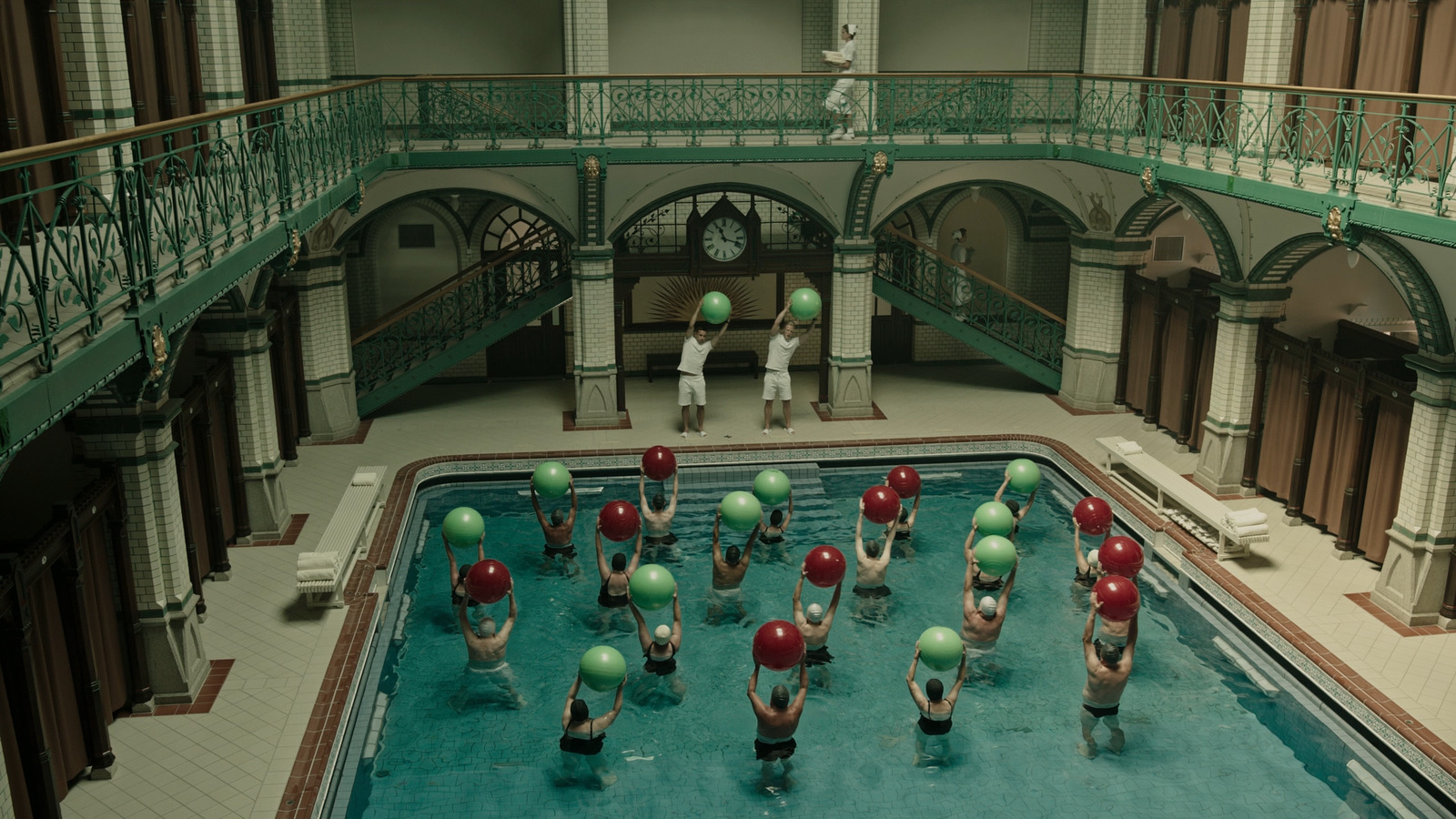 a group of people standing around a swimming pool