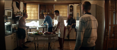 a group of people standing around a kitchen