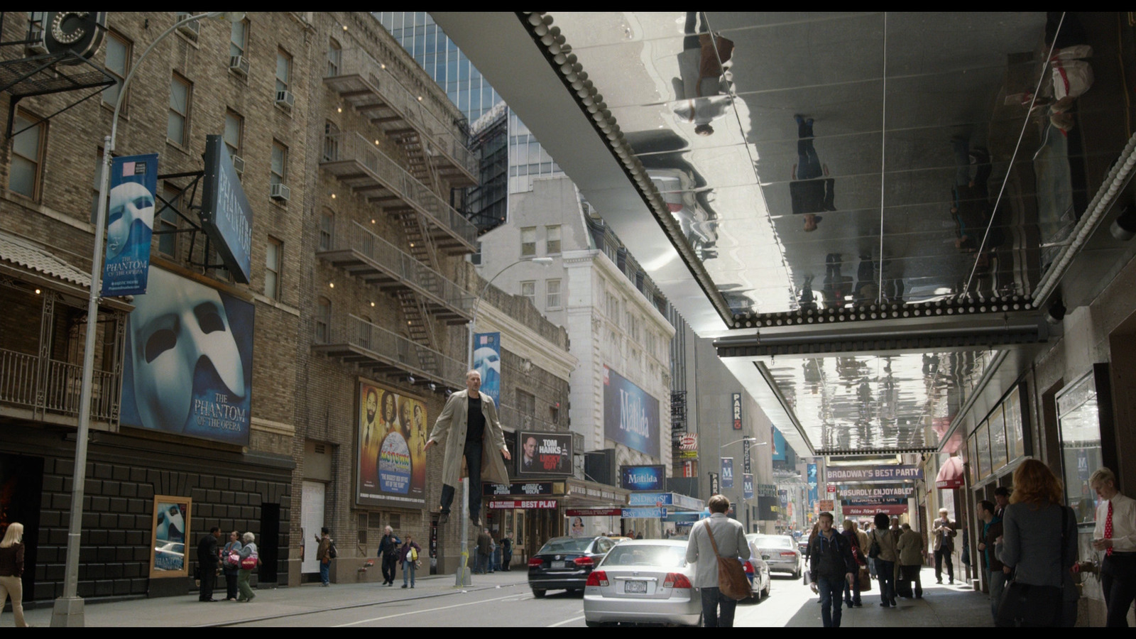 a group of people walking down a street next to tall buildings