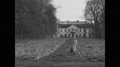 a woman standing in front of a large house