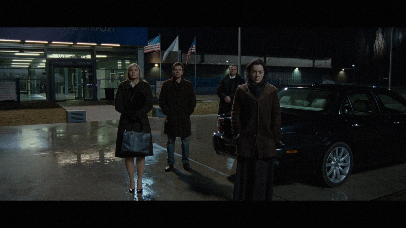 a group of people standing in front of a car