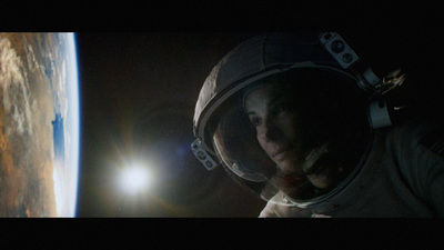 a woman in a space suit looking at the earth