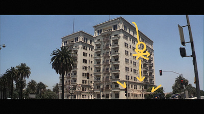 a tall building with a yellow arrow painted on the side of it