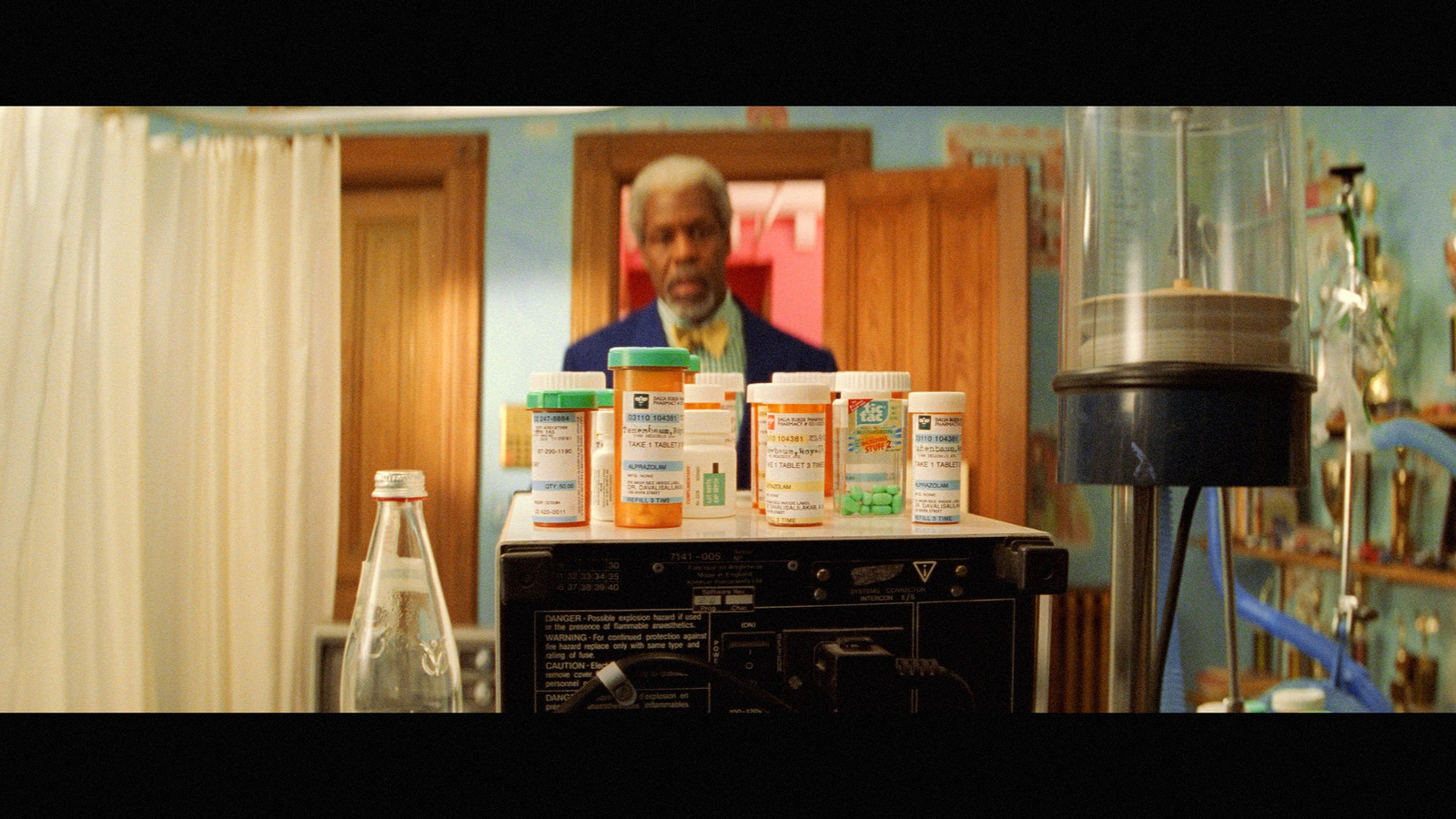 a man standing in front of a stack of medicine bottles