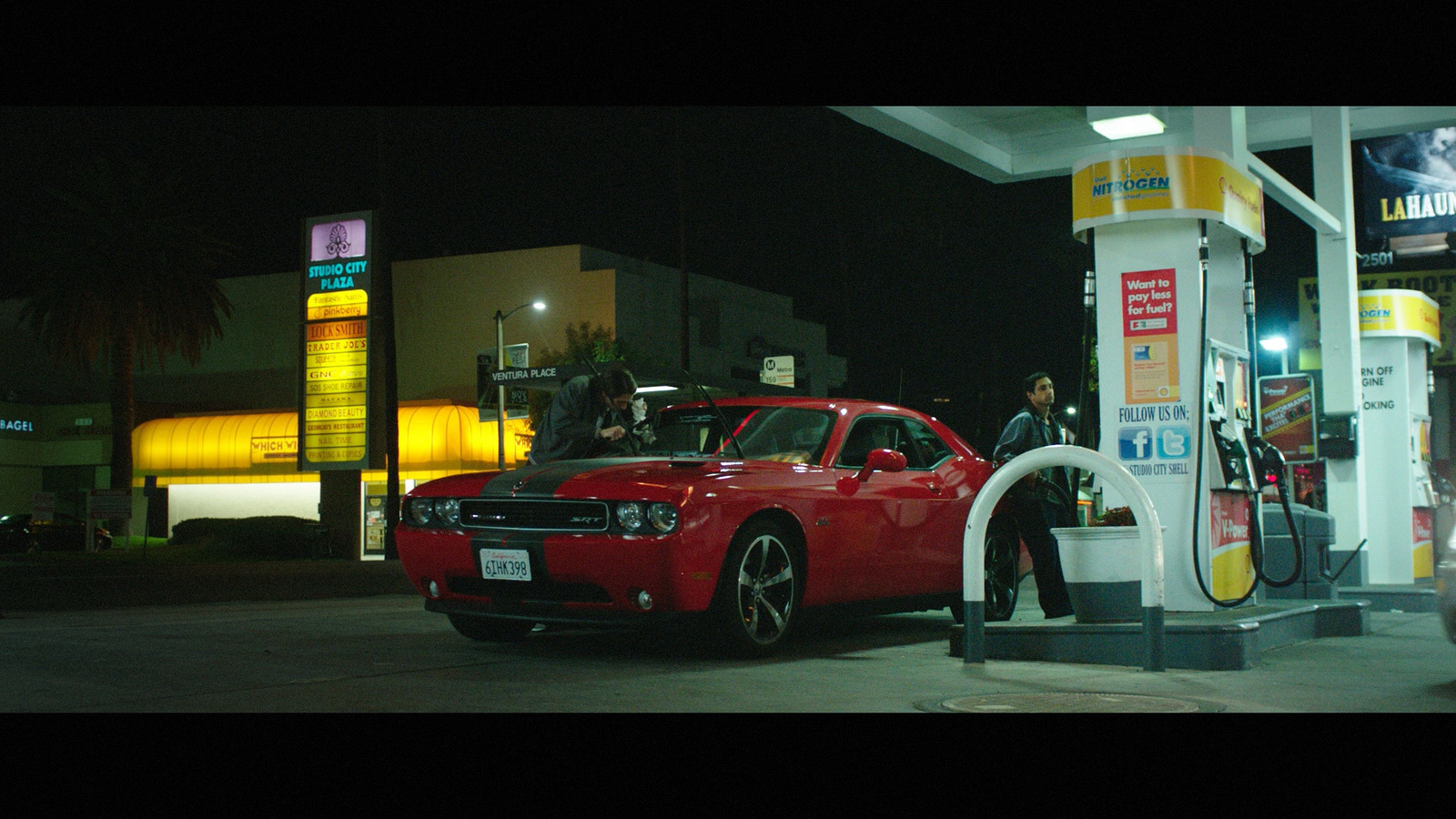 a red car at a gas station at night