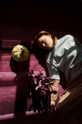 a woman laying on the ground next to a flower