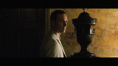 a man standing in front of a wall with a clock on it