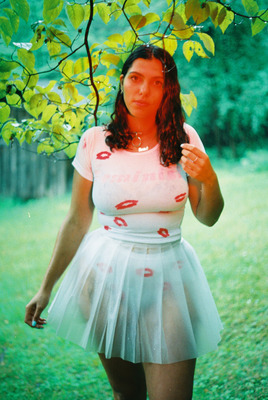 a woman in a white dress standing under a tree