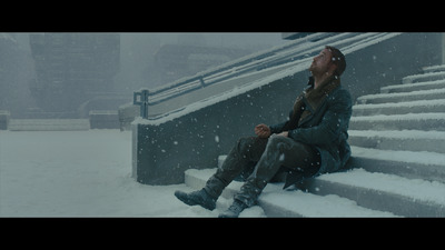 a man sitting on a set of stairs in the snow