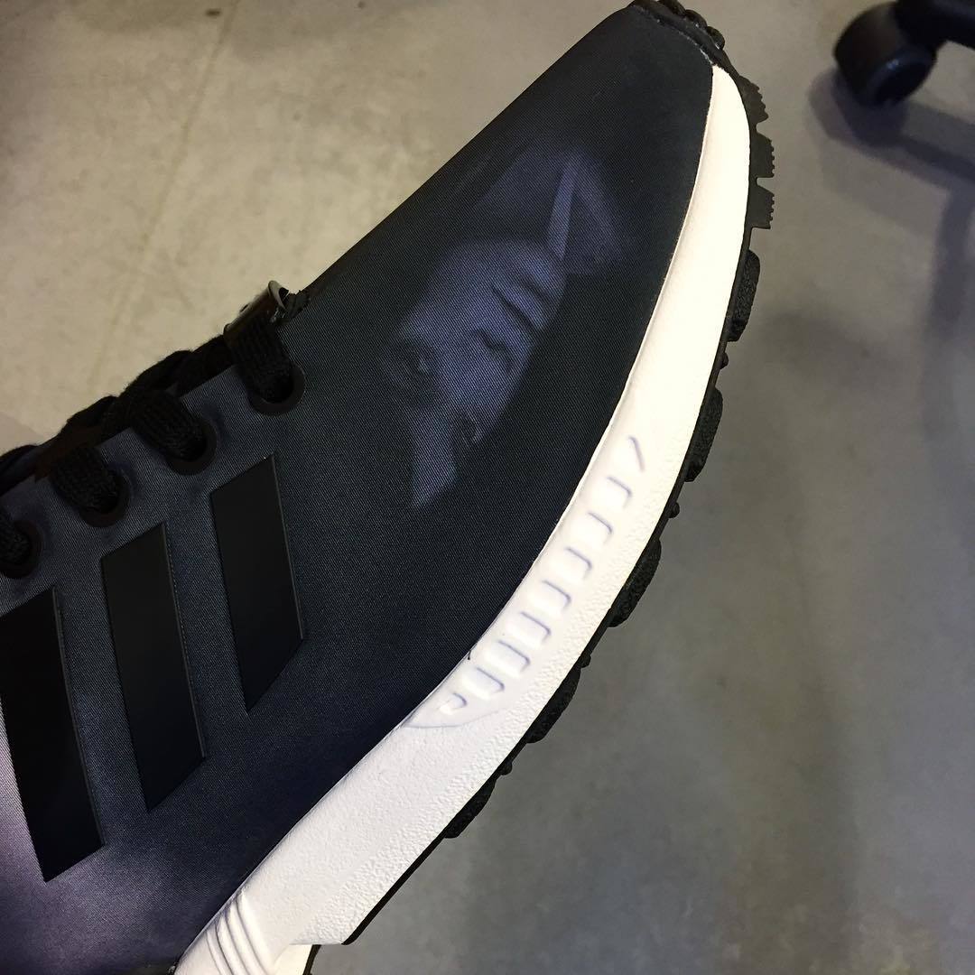 a close up of a black and white adidas shoe