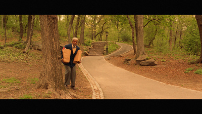 a man standing next to a tree in a forest