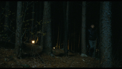 a man standing in the middle of a forest at night