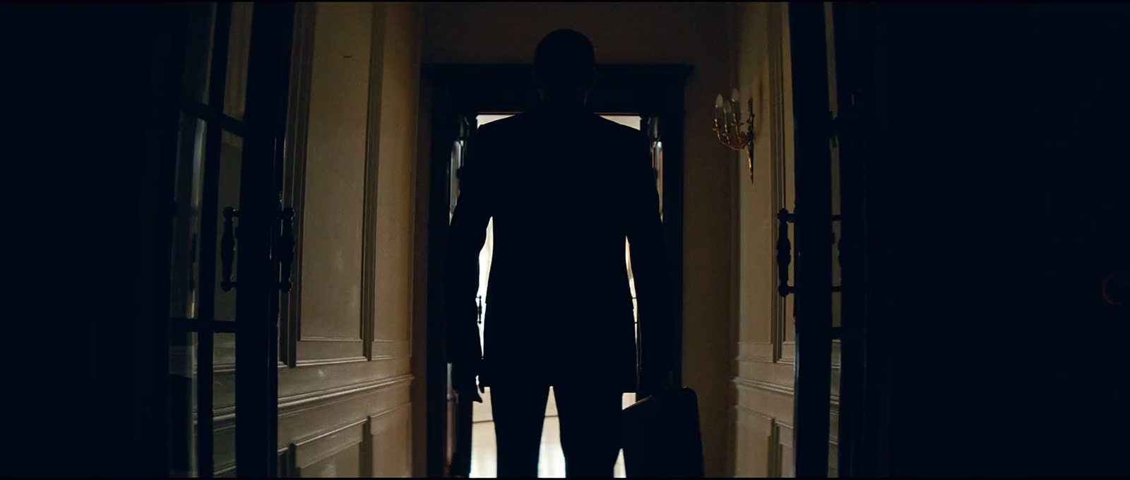 a silhouette of a man standing in a hallway