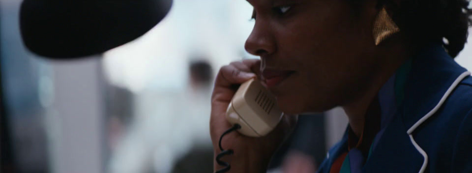 a woman talking on a phone in front of a microphone