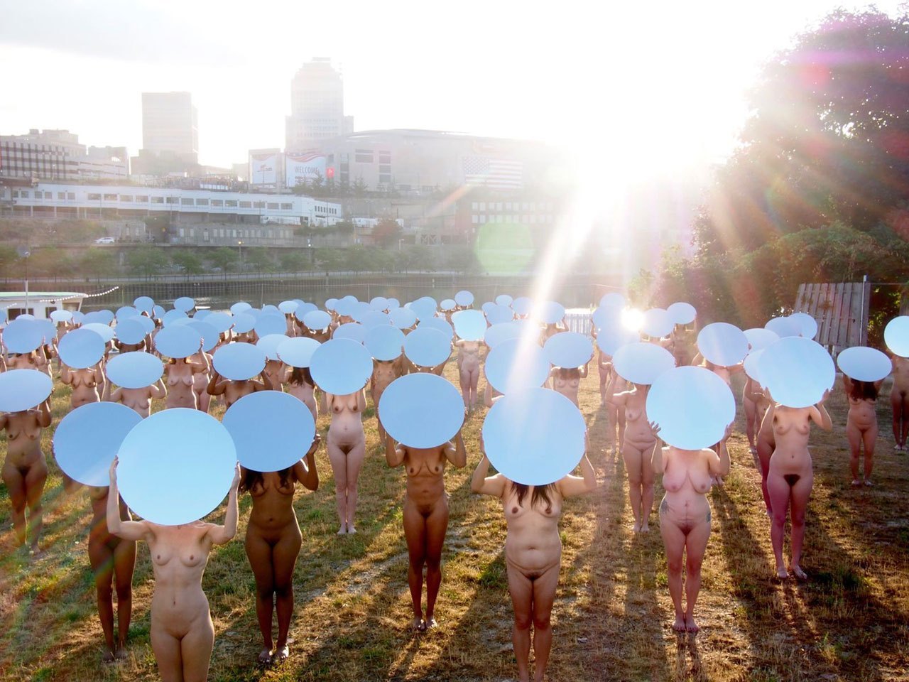 a large group of naked women with mirrors on their heads