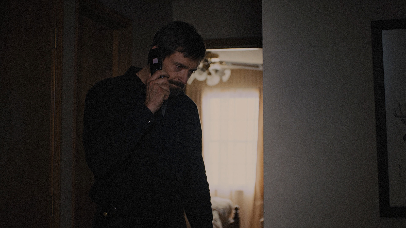 a man talking on a cell phone in a dark room