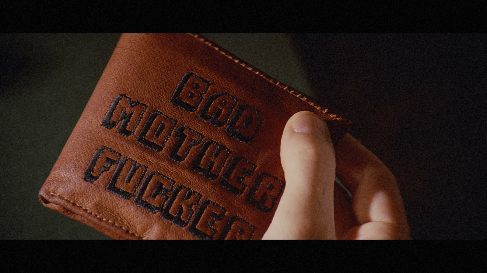 a person holding a brown leather wallet