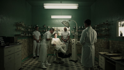 a group of doctors standing around a man in a chair