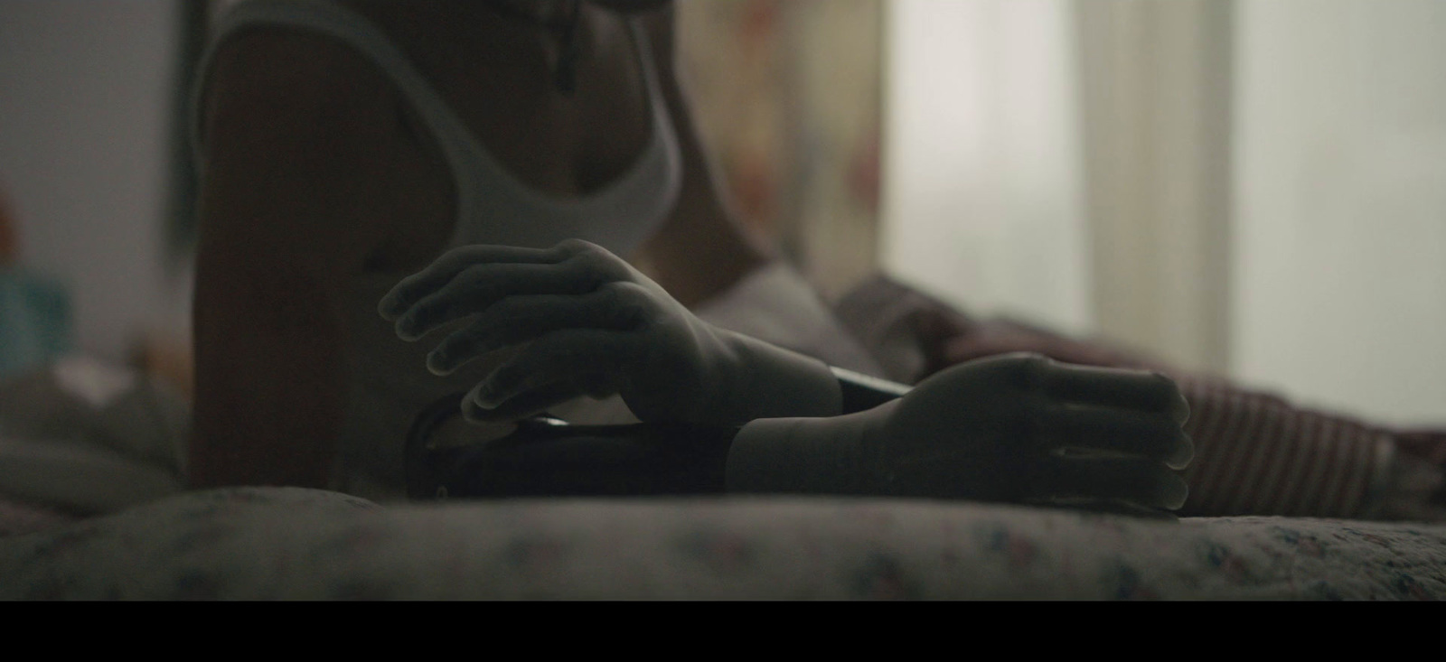 a woman sitting on a bed holding a remote control