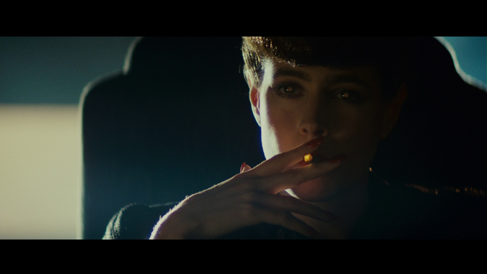 a woman smoking a cigarette in a dark room