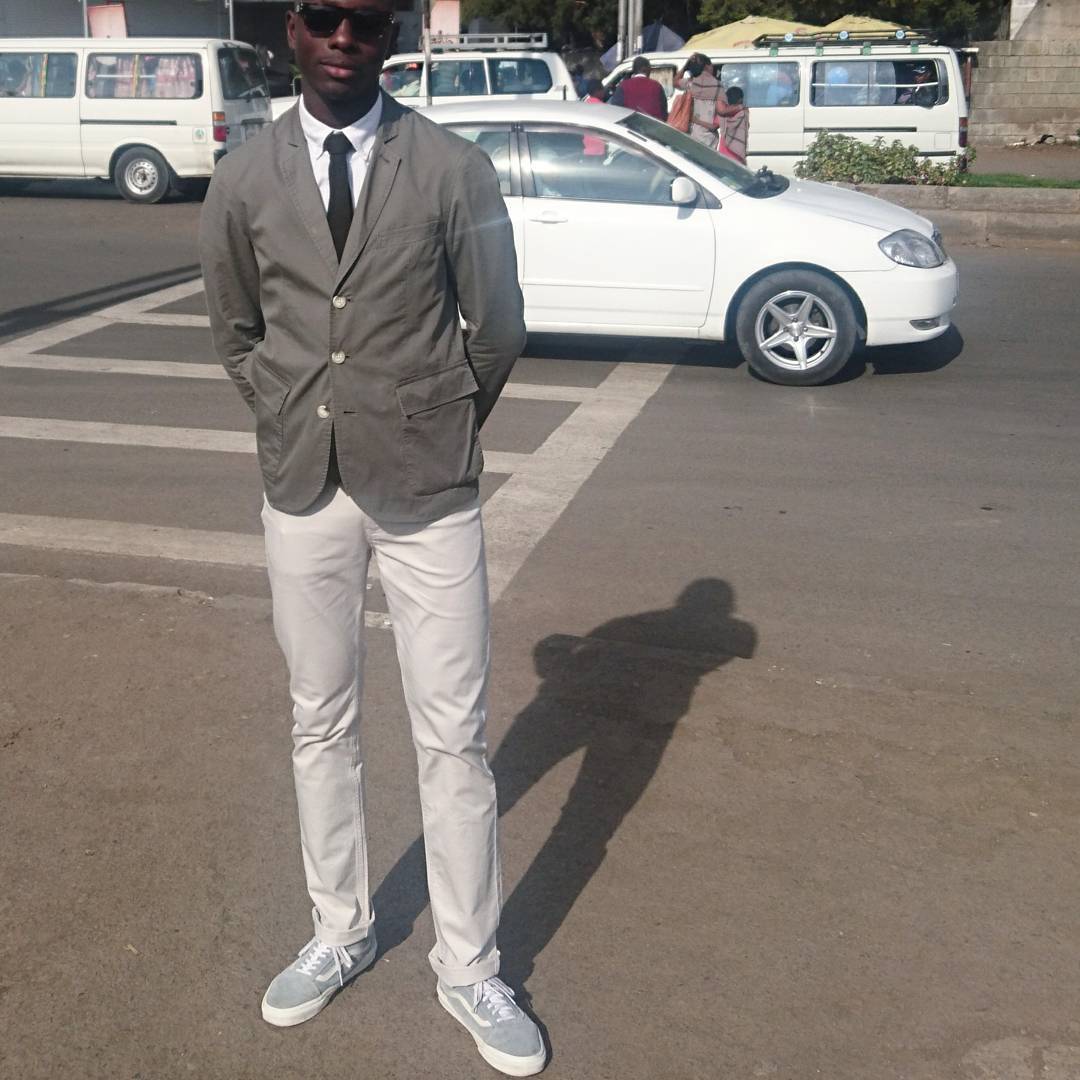 a man in a suit and tie standing in a parking lot