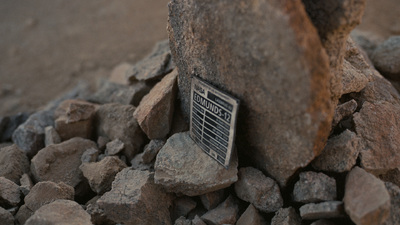 there is a sign that is on the rocks