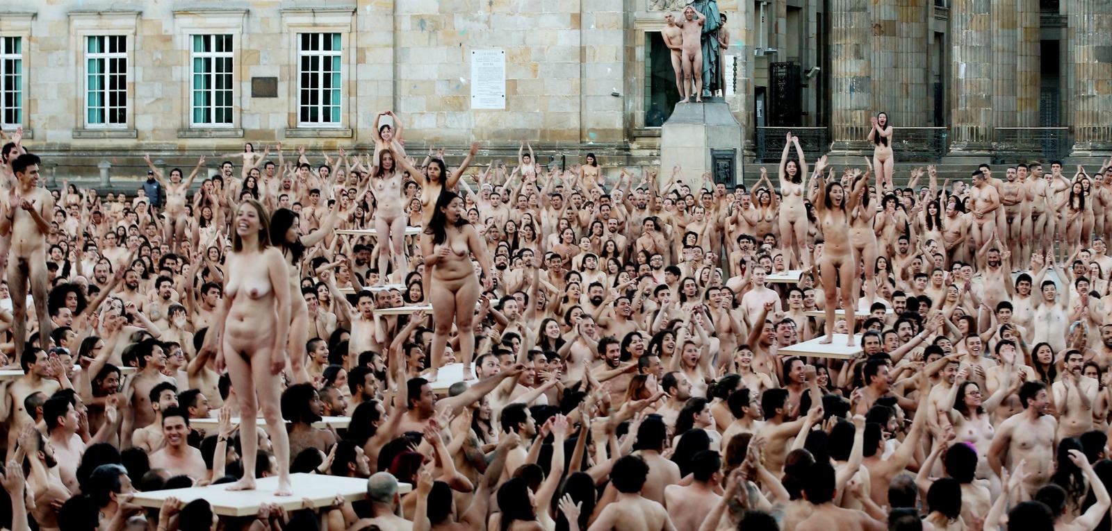 a large group of naked people in front of a building