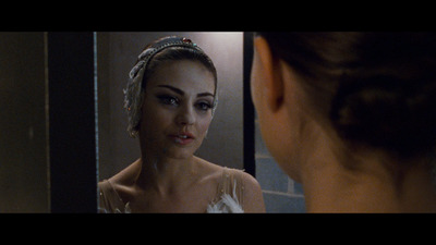 a woman in a white dress looking in a mirror