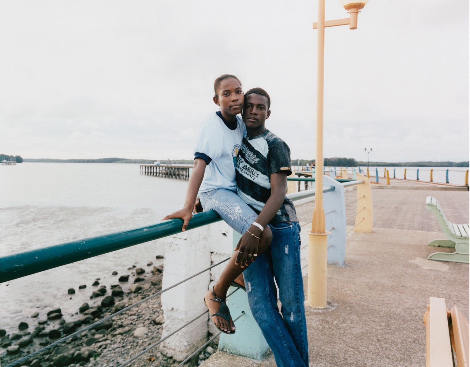 a couple of men standing next to each other near a body of water