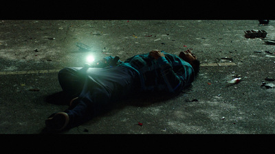 a person laying on the ground with a flashlight