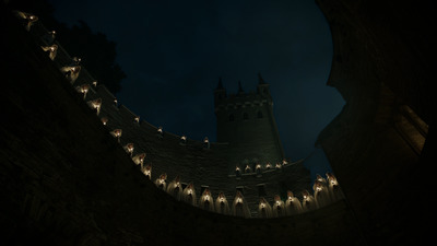 a castle with a clock tower lit up at night