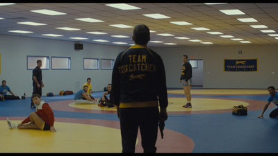 a group of people in a gym with a man on the ground