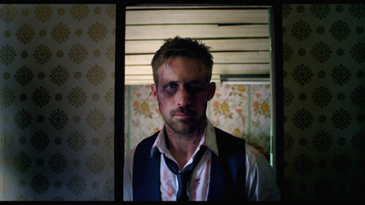 a man in a vest and tie standing in front of a mirror